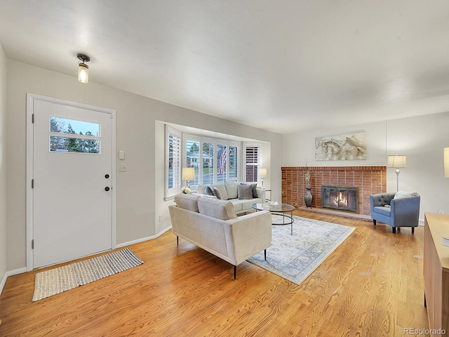 living room with light hardwood / wood-style floors and a brick fireplace