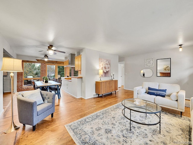 living room with light hardwood / wood-style flooring and ceiling fan