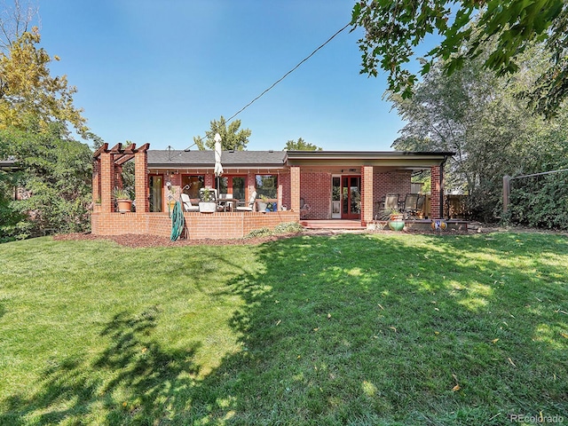 rear view of house featuring a yard and a patio