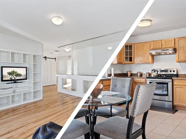 kitchen with a barn door, built in features, light hardwood / wood-style floors, and stainless steel range with electric stovetop