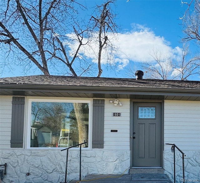 entrance to property with a shingled roof