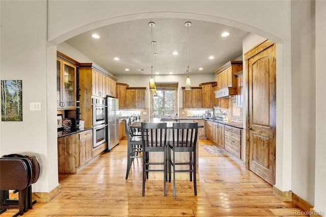 6349 Southridge Greens Blvd, Fort Collins, CO 80525 - kitchen with stainless steel appliances, a kitchen island, light wood finished floors, recessed lighting, and a breakfast bar area