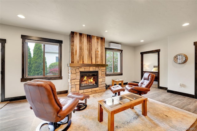 6349 Southridge Greens Blvd, Fort Collins, CO 80525 - living room with an AC wall unit, light wood finished floors, baseboards, recessed lighting, and a stone fireplace