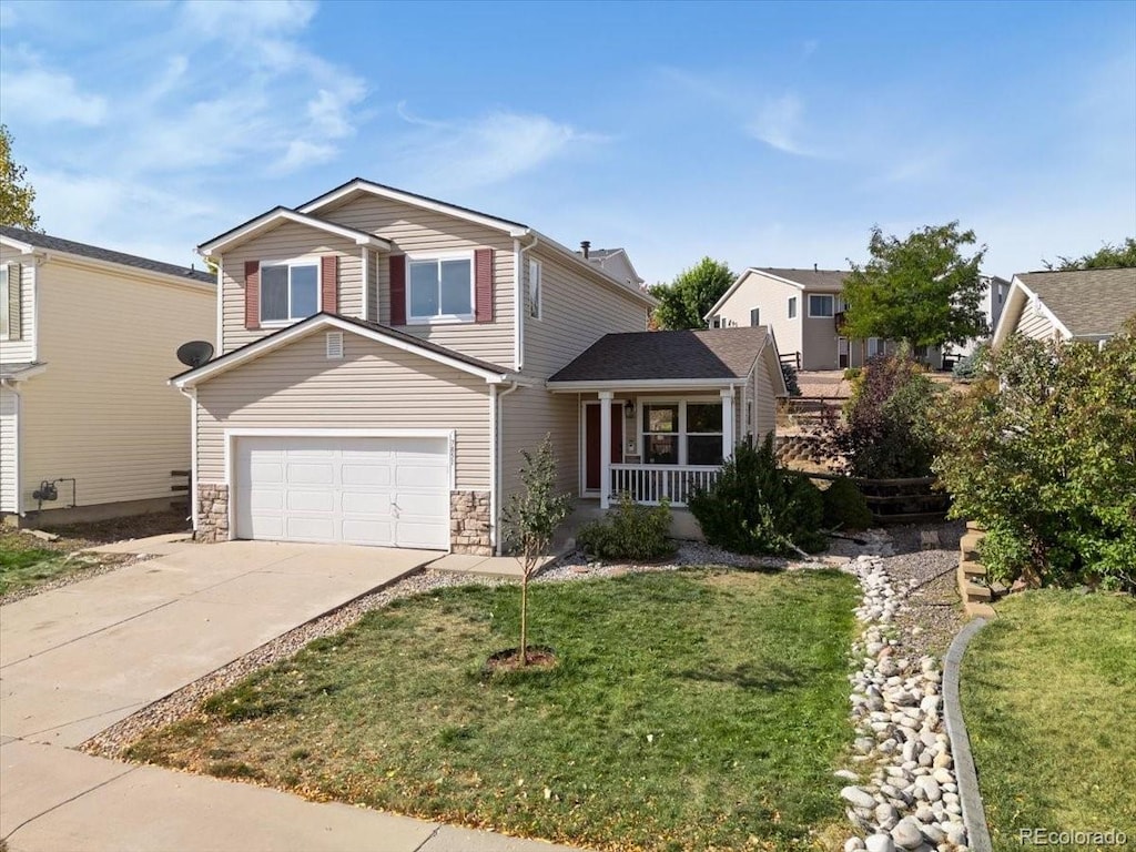 view of front property featuring a garage, a front yard, and covered porch