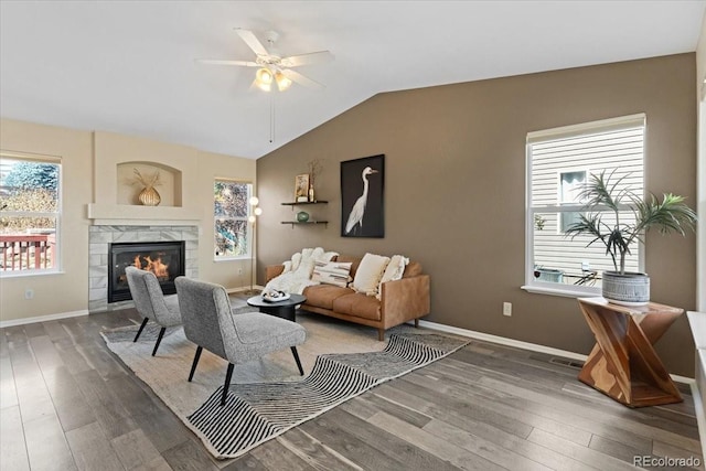 living room with lofted ceiling, a tiled fireplace, plenty of natural light, and dark hardwood / wood-style floors