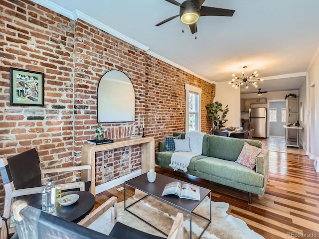 living room featuring light hardwood / wood-style floors, ornamental molding, a wealth of natural light, and an inviting chandelier