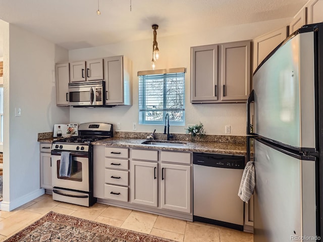 kitchen with hanging light fixtures, gray cabinets, sink, and appliances with stainless steel finishes