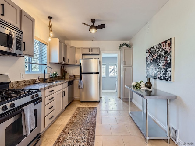 kitchen featuring pendant lighting, sink, ceiling fan, gray cabinets, and appliances with stainless steel finishes