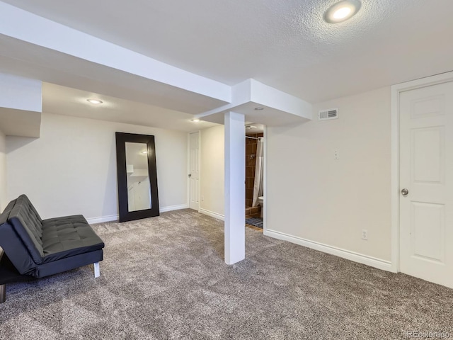 basement with carpet flooring and a textured ceiling