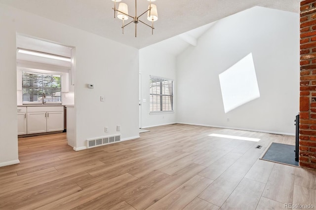 2881 W Long Dr Unit F, Littleton, CO 80120 - unfurnished living room featuring a chandelier, light wood-style floors, and lofted ceiling