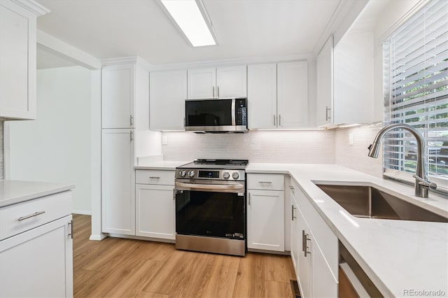 2881 W Long Dr Unit F, Littleton, CO 80120 - kitchen featuring stainless steel appliances, light wood-type flooring, backsplash, and white cabinets