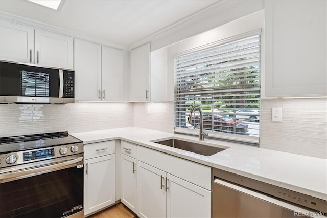 2881 W Long Dr Unit F, Littleton, CO 80120 - kitchen with appliances with stainless steel finishes, white cabinetry, and tasteful backsplash