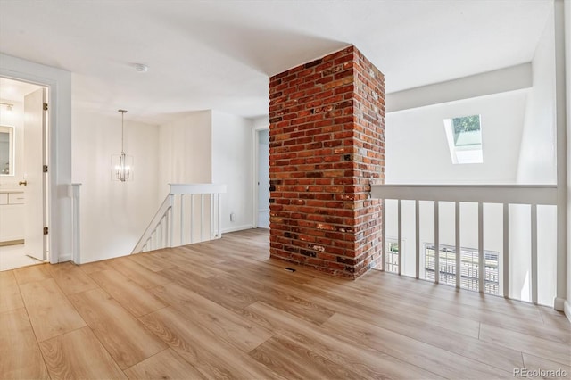 2881 W Long Dr Unit F, Littleton, CO 80120 - unfurnished living room featuring wood finished floors, a skylight, and a chandelier