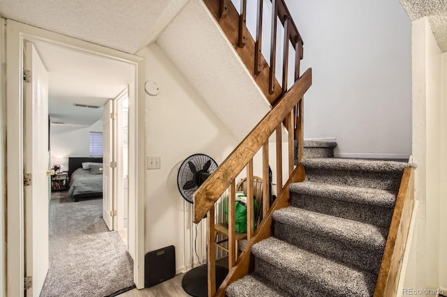staircase featuring carpet and visible vents