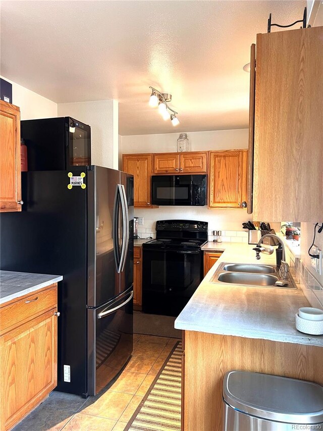 12935 W 64th Dr Unit D, Arvada, CO 80004 - kitchen with black appliances, light countertops, light tile patterned flooring, and brown cabinets
