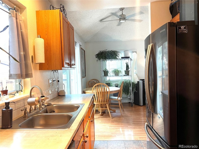 12935 W 64th Dr Unit D, Arvada, CO 80004 - kitchen with freestanding refrigerator, brown cabinetry, a ceiling fan, a textured ceiling, and light countertops