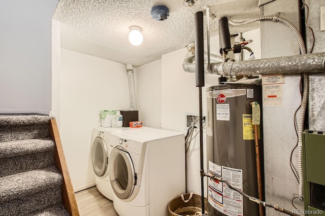 12935 W 64th Dr Unit D, Arvada, CO 80004 - laundry area featuring gas water heater, independent washer and dryer, light wood-style floors, and a textured ceiling