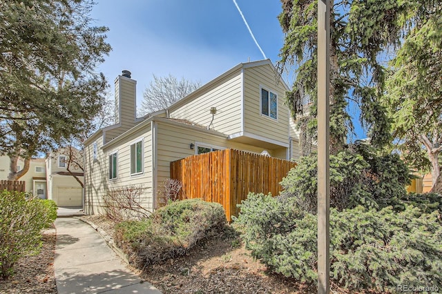 12935 W 64th Dr Unit D, Arvada, CO 80004 - view of side of property featuring a chimney and a garage