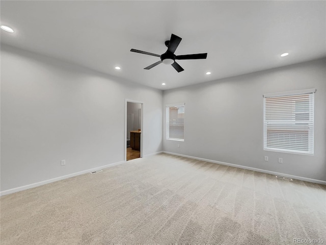 unfurnished room with light colored carpet and ceiling fan