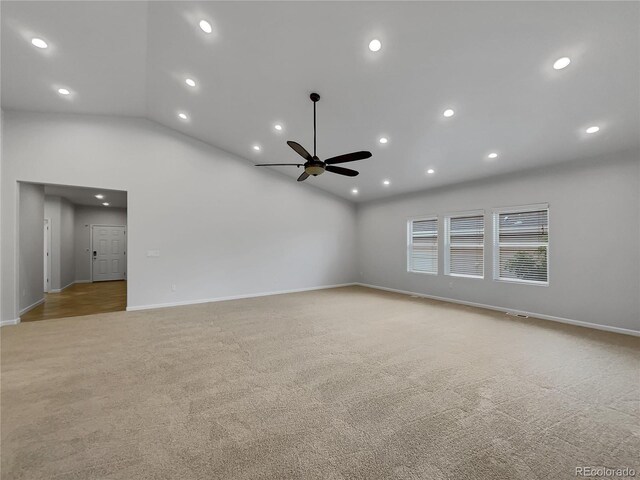 carpeted empty room featuring high vaulted ceiling and ceiling fan