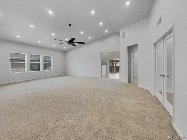 unfurnished living room featuring high vaulted ceiling, light colored carpet, and ceiling fan