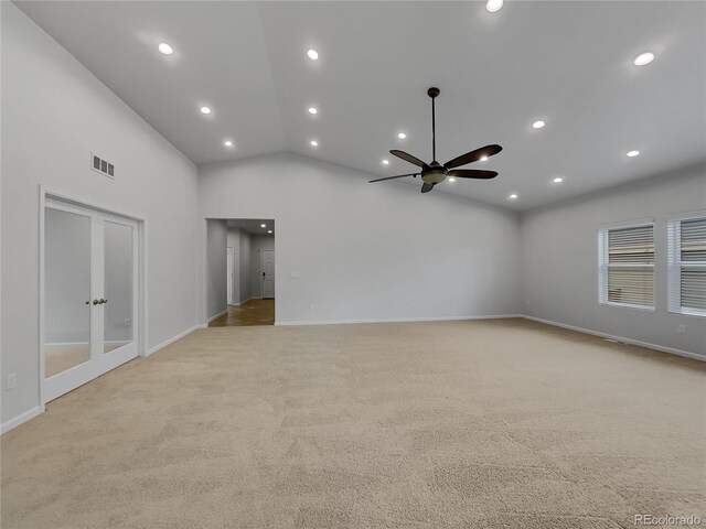 carpeted empty room with high vaulted ceiling and ceiling fan