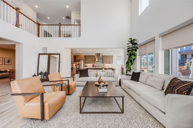 living area featuring light wood-type flooring, plenty of natural light, visible vents, and recessed lighting