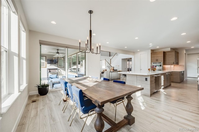 dining space featuring baseboards, stairs, light wood-type flooring, a notable chandelier, and recessed lighting