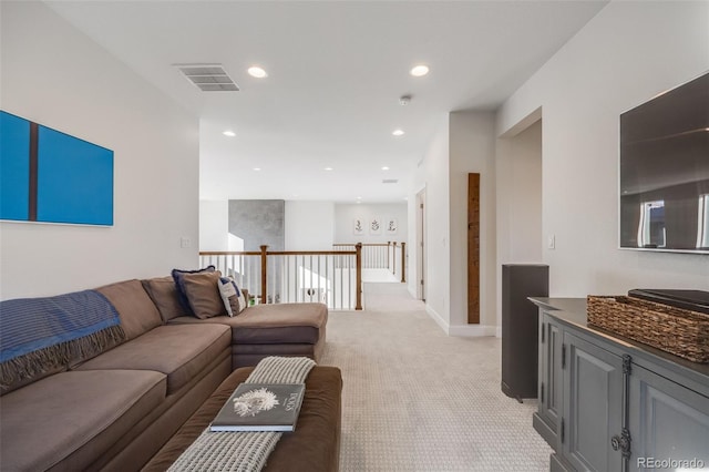 living area with recessed lighting, visible vents, baseboards, and light colored carpet