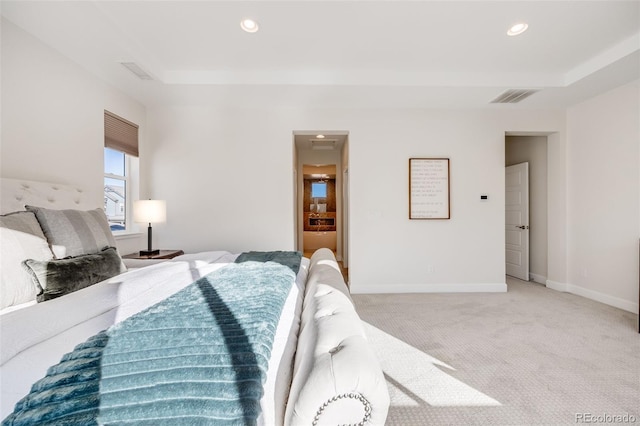 bedroom with light carpet, a raised ceiling, visible vents, and baseboards