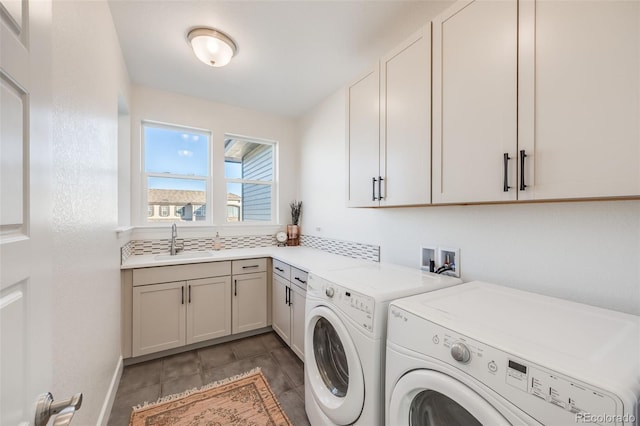 laundry area featuring cabinet space, washer and clothes dryer, and a sink