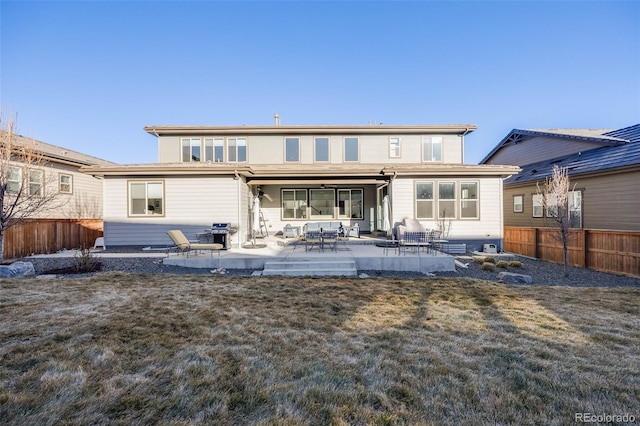 back of property with a patio area, a fenced backyard, and a yard