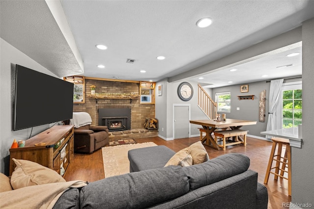 5211 Parmalee Gulch Rd, Indian Hills, CO 80454 - living room featuring stairs, wood finished floors, recessed lighting, a fireplace, and a textured ceiling