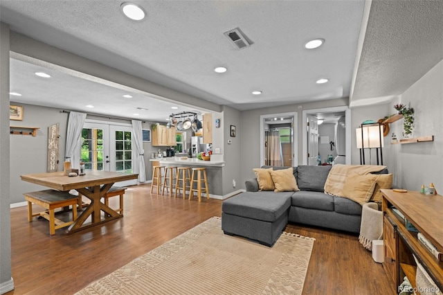 5211 Parmalee Gulch Rd, Indian Hills, CO 80454 - living area with french doors, wood finished floors, a textured ceiling, and recessed lighting