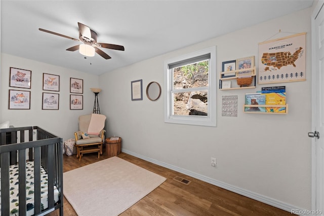5211 Parmalee Gulch Rd, Indian Hills, CO 80454 - bedroom with wood finished floors, a crib, and a ceiling fan