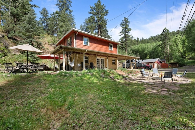5211 Parmalee Gulch Rd, Indian Hills, CO 80454 - back of property with an outdoor fire pit, a patio area, a yard, and brick siding