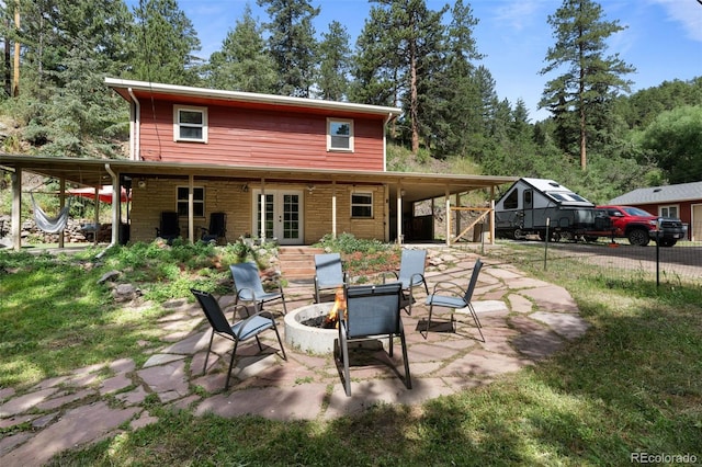 5211 Parmalee Gulch Rd, Indian Hills, CO 80454 - rear view of property featuring french doors, an outdoor fire pit, and a patio