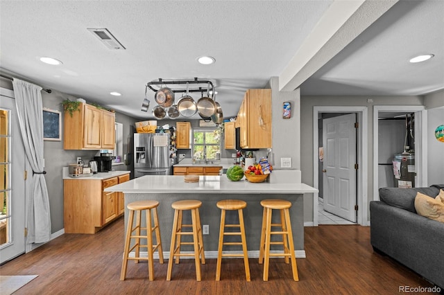 5211 Parmalee Gulch Rd, Indian Hills, CO 80454 - kitchen with stainless steel refrigerator with ice dispenser, a peninsula, recessed lighting, light countertops, and a kitchen bar