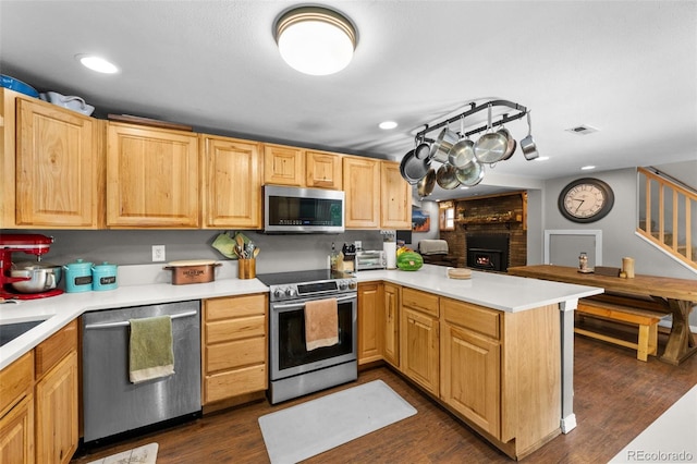 5211 Parmalee Gulch Rd, Indian Hills, CO 80454 - kitchen featuring stainless steel appliances, a peninsula, a fireplace, light countertops, and recessed lighting