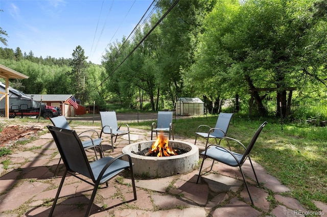 5211 Parmalee Gulch Rd, Indian Hills, CO 80454 - view of patio with a fire pit, an exterior structure, and an outbuilding