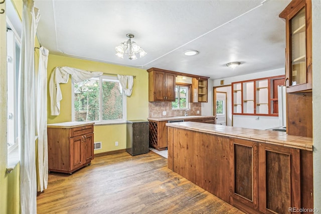1457 S Franklin St, Denver, CO 80210 - kitchen with light wood-style flooring, open shelves, a chandelier, decorative backsplash, and baseboards