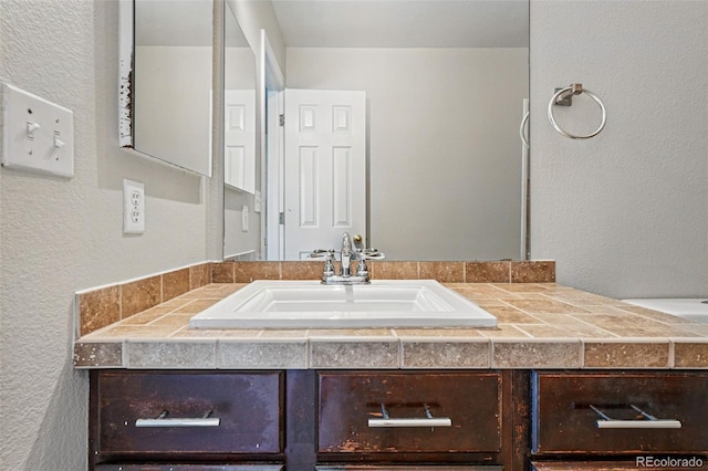 bathroom featuring vanity and a textured wall