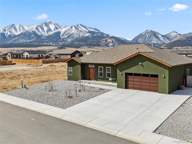 ranch-style house featuring a mountain view, an attached garage, and stucco siding