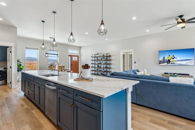 kitchen with washer / clothes dryer, stainless steel dishwasher, light wood-type flooring, a sink, and open floor plan