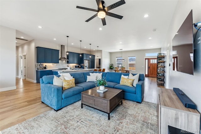 living room featuring recessed lighting, ceiling fan, baseboards, and light wood-type flooring
