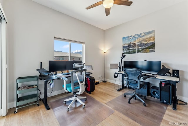 office space featuring baseboards, ceiling fan, and wood finished floors