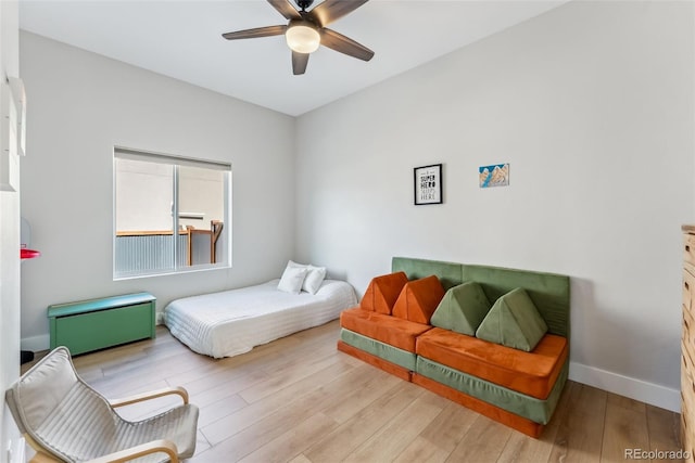 bedroom featuring a ceiling fan, baseboards, and wood finished floors