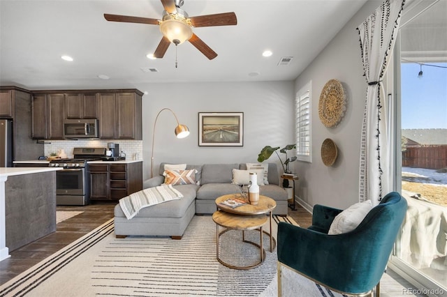 living room with ceiling fan and dark hardwood / wood-style floors