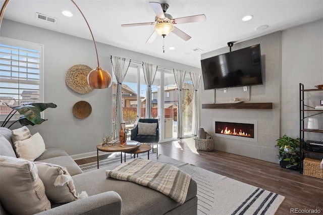 living room with ceiling fan, a fireplace, and dark hardwood / wood-style flooring