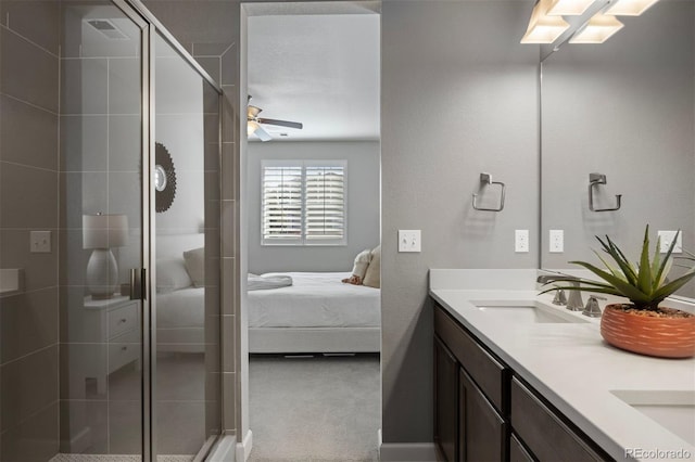 bathroom featuring vanity, a shower with shower door, and ceiling fan